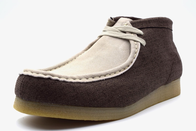 May include: Brown canvas and suede ankle boots with a lace-up closure.