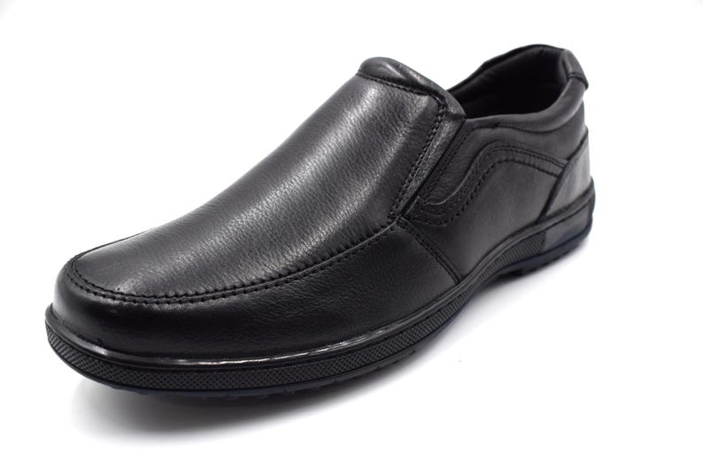 May include: Black leather slip-on shoes with a smooth finish and a rubber sole.