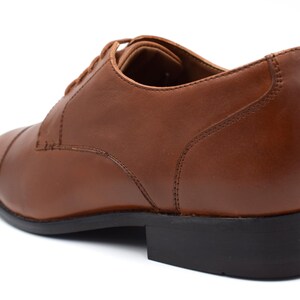 May include: Brown leather lace-up dress shoes with a black rubber sole.