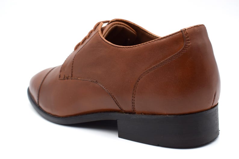 May include: Brown leather lace-up dress shoes with a black rubber sole.