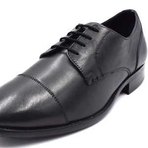 May include: Black leather lace-up dress shoes with a cap toe design.