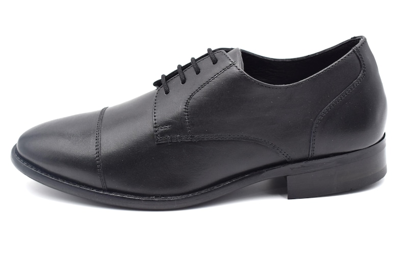 May include: Black leather lace-up dress shoes with a cap toe.