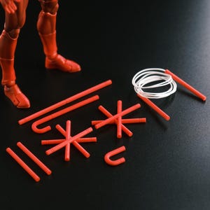 Puede incluir: Un conjunto de accesorios de porra de plástico rojo para figura de acción, que incluye varillas rectas, varillas con gancho, conectores en forma de estrella y una cuerda blanca enrollada. El texto dice: PURCHASE DOES NOT INCLUDE DAREDEVIL FIGURE.
