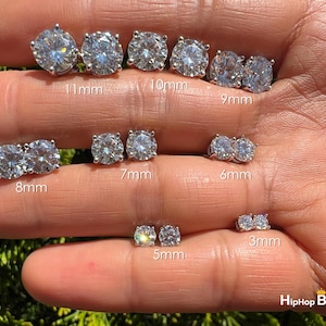 May include: A set of 10 pairs of round, clear cubic zirconia earrings in various sizes, ranging from 3mm to 11mm. The earrings are displayed on a hand, with each size labeled in millimeters.
