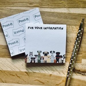 Könnte beinhalten: Ein quadratischer, weißer Haftnotizblock mit dem Text "FUR YOUR INFORMATION" am oberen Rand und einer bunten Illustration verschiedener Hunderassen am unteren Rand, begleitet von einem goldfarbenen Stift mit weißen Punkten.
