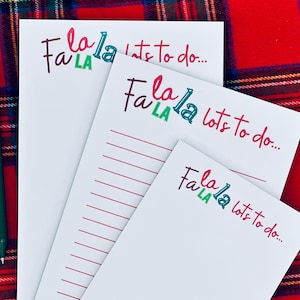 Peut inclure: Trois blocs-notes blancs avec le texte "Fa La La lots to do..." en rouge, vert et violet. Les blocs-notes sont sur un fond à carreaux rouge et vert. Un bloc-notes a des pages lignées.