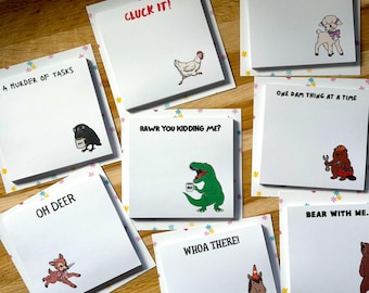 Puede incluir: Una colección de blocs de notas adhesivas cuadrados de color blanco con varias ilustraciones de animales y textos humorísticos como Cluck It, A Murder of Tasks, Rawr You Kidding Me, One Dam Thing at a Time, Oh Deer, Whoa There y Bear With Me.