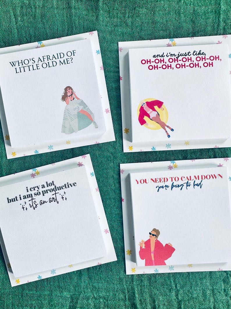 May include: Four white sticky note pads with colorful floral borders and illustrations of a woman. The text on the pads reads "Who's afraid of little old me?", "i cry a lot but i am so productive it's an art", "and i'm just like, OH-OH, OH-OH, OH-OH, OH-OH, OH-OH, OH", and "YOU NEED TO CALM DOWN you're being too loud".
