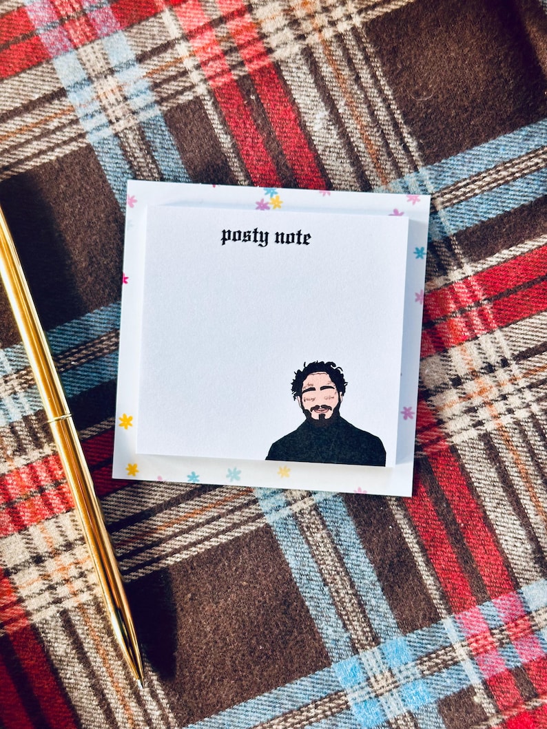 May include: A white sticky note with the text "posty note" printed in black at the top. A black and white illustration of a person with facial tattoos is at the bottom of the note.