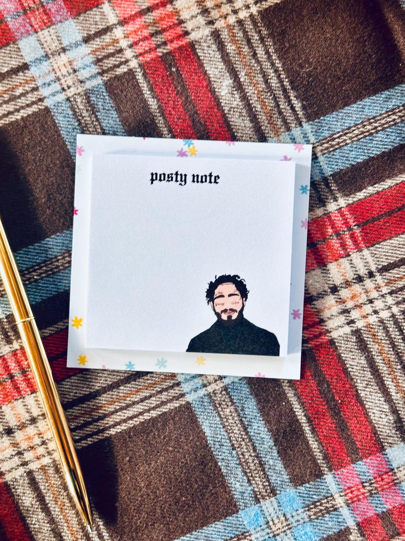 May include: A white sticky note with the text "posty note" in black gothic font. A cartoon illustration of a man with a beard and black hair is at the bottom of the note.