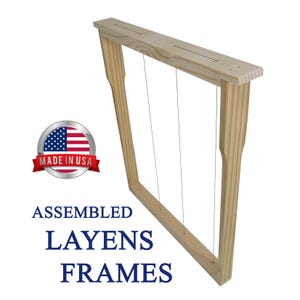 May include: Assembled Layens frames made in the USA. The wooden frame has three vertical wires strung across it. The frame is made of light-colored wood and is designed for beekeeping.