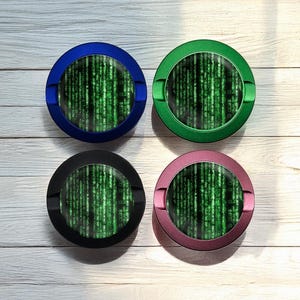 May include: Four round ashtrays in blue, green, black, and pink. Each ashtray features a green digital rain pattern on the inside. The ashtrays are made of metal and have a small notch for resting cigarettes.