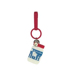 May include: A red keychain with a white and blue marshmallow fluff jar charm. The jar has a red lid and the words "Marshmallow Fluff" and "fluff" printed on it. A small silver charm is attached.