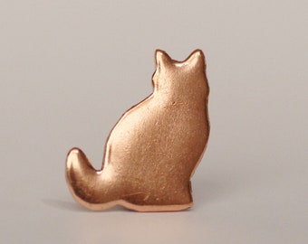 May include: A copper-colored metal cat silhouette. The cat is sitting with its tail curled around its body.
