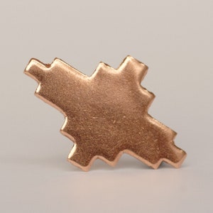 May include: A copper-colored metal pendant in the shape of a stylized star with a textured surface.