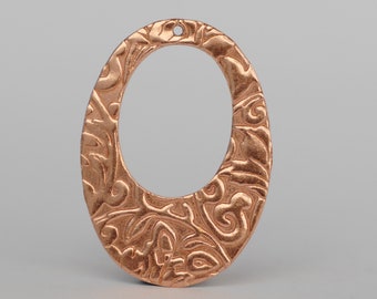 May include: A copper oval pendant with an intricate floral design. The pendant has a hole at the top for hanging.