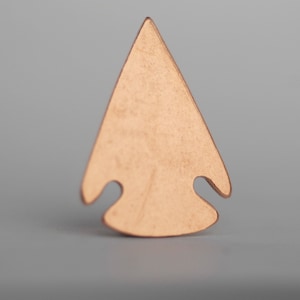 May include: A copper arrowhead pendant with a triangular shape and two small holes on the bottom.