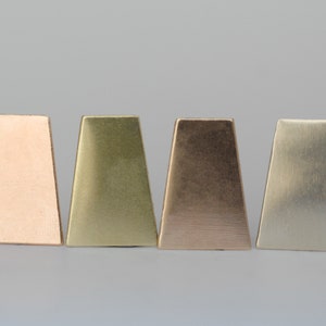 May include: Four trapezoid-shaped metal samples in different colors: rose gold, brass, copper, and silver.