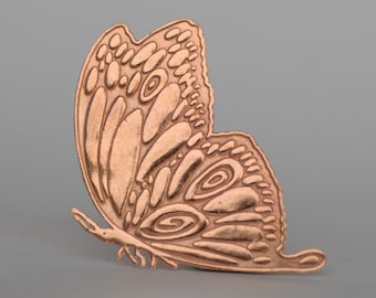 May include: A copper-colored metal butterfly with intricate, detailed wings. The butterfly is a decorative piece with a three-dimensional design.