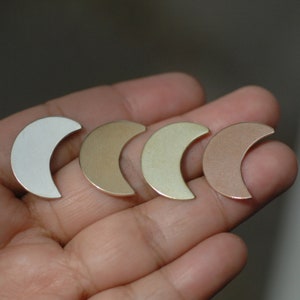 May include: Four crescent moon shapes in different metallic finishes: silver, gold, light gold, and copper.