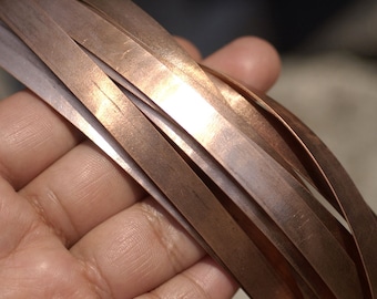 May include: A close-up of a bundle of thin, flat copper strips. The strips are shiny and have a warm, metallic colour.