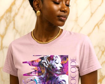 May include: A light pink t-shirt featuring a vibrant graphic design with the word "ETHNOCODE" in purple. The design includes abstract portraits with purple and gold accents. The model is wearing gold jewelry.