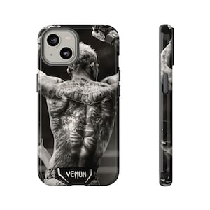 May include: Black and white phone case featuring a photo of a man with tattoos on his back. The man is wearing black shorts with the word "VENUM" printed on them.