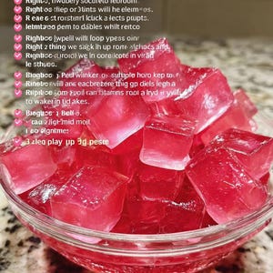 May include: A glass bowl containing red jelly cubes. The image has text at the top that reads "JELLLO SPEEK HAIR". The jelly cubes are a bright red colour and appear to be freshly made.