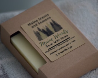 May include: A bar of Maine Woods Goat Milk Soap in a brown cardboard box. The label reads "Maine Woods Goat Milk Soap" with a forest graphic. The soap weighs 3.5 oz.