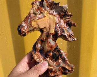 May include: A handcrafted stone horse head sculpture. The sculpture features a mosaic of colors including brown, tan, black, and gray. The horse head is a decorative item, perfect for home decor or as a unique gift.