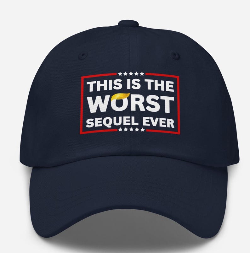 Pu&ograve; includere: Cappellino da baseball blu navy con la scritta "THIS IS THE WORST SEQUEL EVER" in lettere bianche all'interno di un rettangolo rosso. La parola "WORST" ha una grafica di capelli gialli sopra. Il cappellino ha una visiera curva e una corona rotonda.