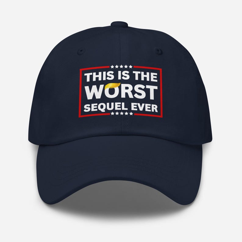 Pu&ograve; includere: Cappellino da baseball blu navy con la scritta "THIS IS THE WORST SEQUEL EVER" in lettere bianche all'interno di un rettangolo rosso. La parola "WORST" ha un disegno giallo a forma di capelli sopra. Il cappellino ha una visiera curva.