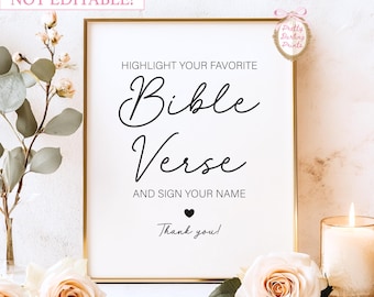 May include: A framed white print with gold trim features the text "HIGHLIGHT YOUR FAVORITE Bible Verse AND SIGN YOUR NAME." The words are in black script. The print is surrounded by flowers and a lit candle.