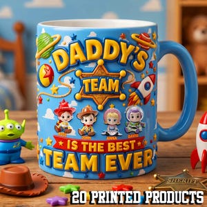 May include: A blue ceramic mug with a handle, featuring the text "DADDY'S TEAM IS THE BEST TEAM EVER" and cartoon characters. The mug has a blue handle and is decorated with stars, a rocket, and a sheriff's badge. Additional toy figures are visible.