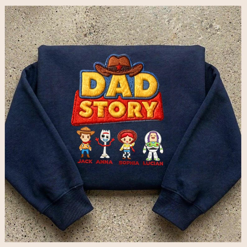 May include: Navy blue sweatshirt featuring the embroidered phrase "DAD STORY" in yellow and red, with a brown cowboy hat above. Below are embroidered cartoon characters and names: Jack, Anna, Sophia, and Lucian.