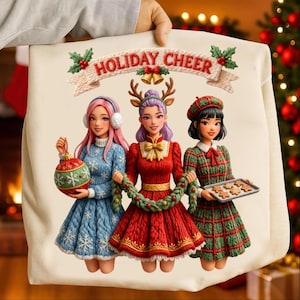 Puede incluir: Una sudadera de color crema con un diseño festivo. La imagen muestra a tres mujeres de dibujos animados, cada una con un atuendo navideño. El texto "HOLIDAY CHEER" se muestra encima de ellas. Una mujer sostiene una bola de Navidad, otra una guirnalda y la tercera una bandeja de galletas.