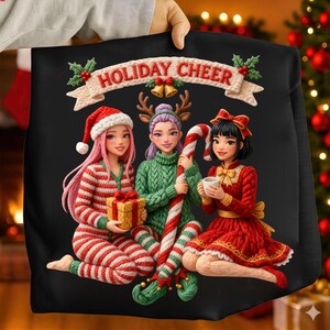 Puede incluir: Sudadera negra con temática navideña con el texto "HOLIDAY CHEER" sobre tres figuras de dibujos animados. Las figuras visten atuendos festivos, incluyendo un gorro de Papá Noel, cuernos de reno y un vestido rojo. Una figura sostiene un regalo.
