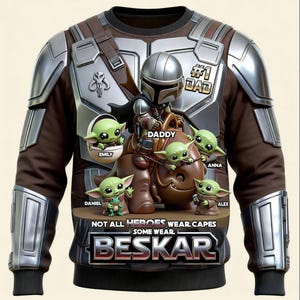 Puede incluir: Sudadera marr&oacute;n y plateada con un dise&ntilde;o inspirado en el Mandaloriano, personajes de Grogu y el texto "#1 DAD". El dise&ntilde;o incluye el texto "NOT ALL HEROES WEAR CAPES SOME WEAR BESKAR".