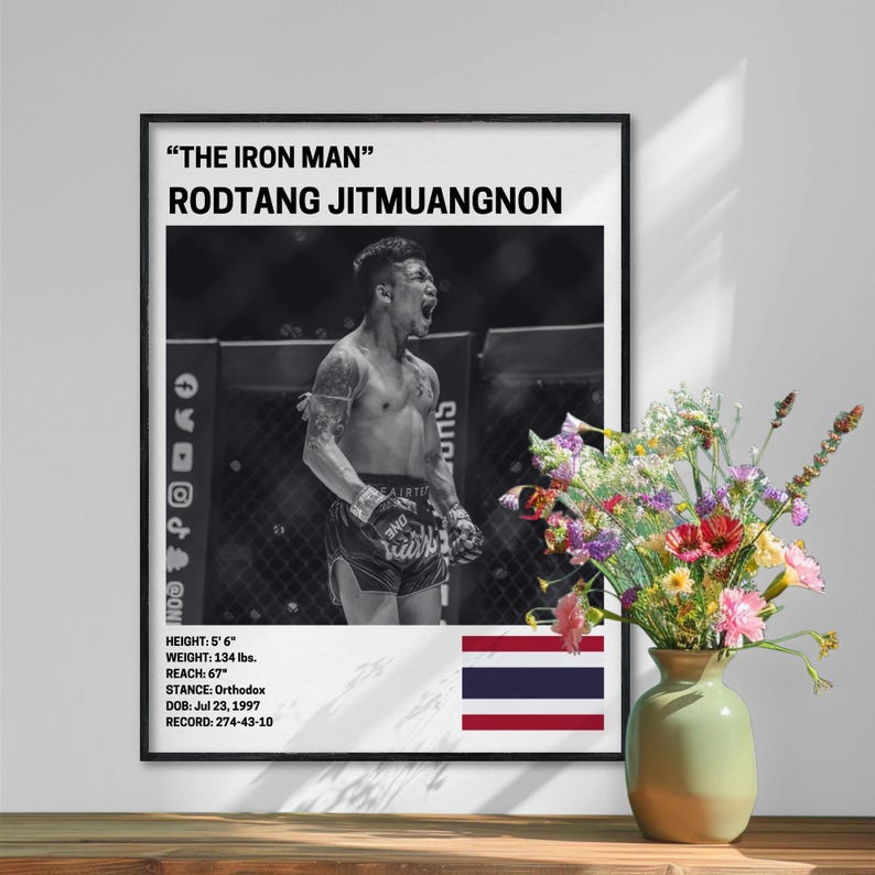 a framed poster of a fighter, with a vase of flowers placed next to it on a table.