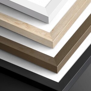 a close-up view of a collection of wooden frames in various colors and finishes, including white, light brown, and dark brown.