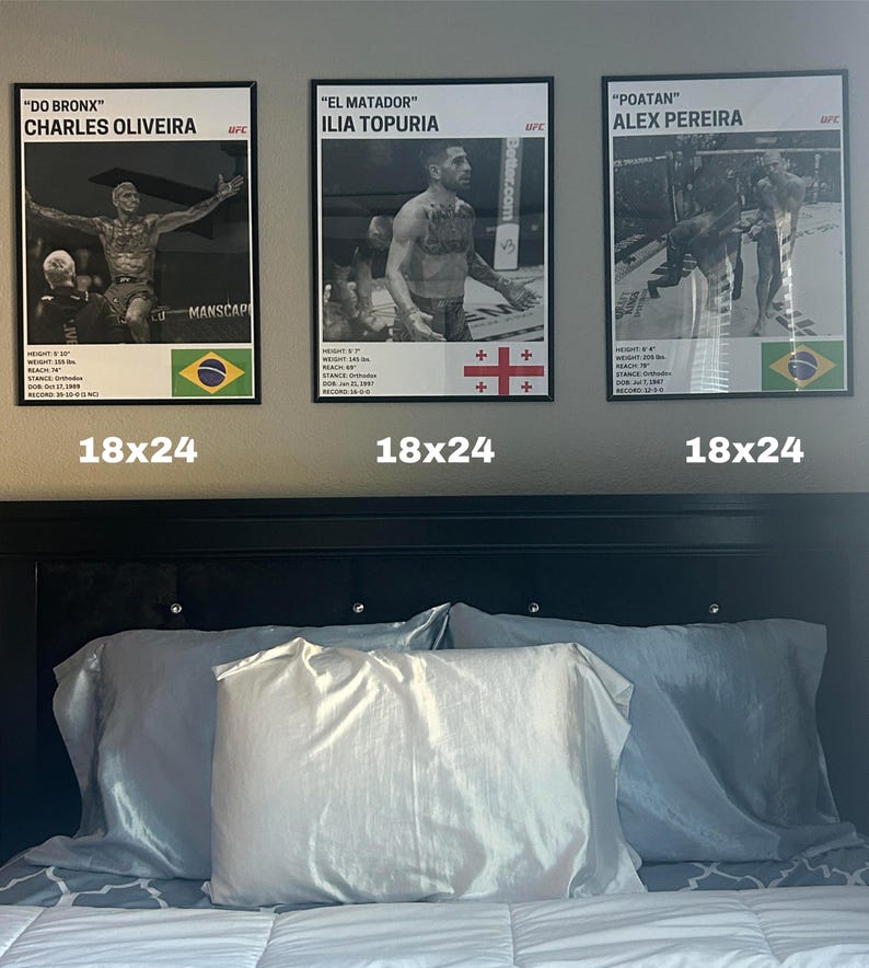 three framed posters of professional boxers, each with a different fighter's name and image, displayed above a bed with white pillows.