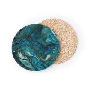 May include: A set of two round coasters. One coaster features a blue and green marble design with gold accents. The other coaster is made of cork.