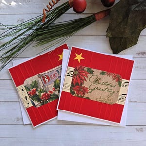 May include: Two square greeting cards with a red textured background, each featuring a yellow star and a horizontal strip of vintage-style paper. One card displays holly berries and the text Dec, while the other shows poinsettias and Christmas Greeting.