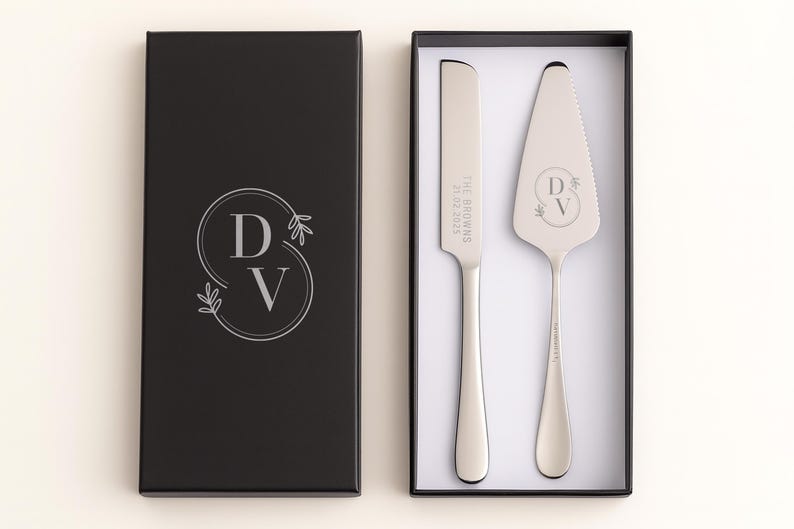 May include: A wedding cake serving set in a black gift box. The set includes a cake knife and server with engraved initials and date. The box has a matching monogram design. A perfect gift for a wedding or anniversary.