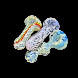 Peut inclure: Trois pipes &agrave; fumer en verre avec des motifs color&eacute;s. Les pipes sont en verre transparent avec des tourbillons de couleur, notamment arc-en-ciel, blanc et bleu.