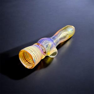 May include: A glass pipe with a swirling iridescent design in shades of yellow, blue, and purple. The pipe has a wide bowl and a long, slender stem.
