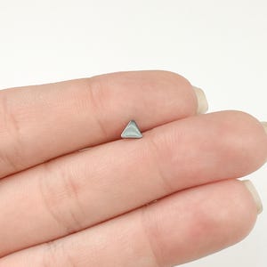 May include: A silver triangle stud earring.