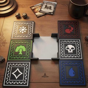 May include: A tabletop game play mat with six black and white square tiles featuring symbols, arranged around a central white area. Dice, game cards, and a mug are also visible on the wooden surface.