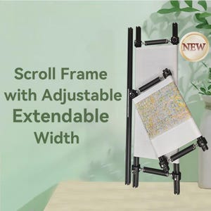 May include: Black scroll frame with adjustable, extendable width, holding a piece of fabric with a colorful pattern. The frame has a "NEW" sticker. The text "Scroll Frame with Adjustable Extendable Width" is displayed.