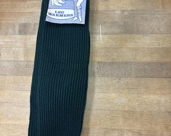 Könnte beinhalten: Ein Paar dunkelgrüne, gerippte Strickstulpen oder Stiefelstulpen. Der Artikel verfügt über ein Papieretikett an der Oberseite mit blau-weißen Grafiken, die zeigen, wie das Produkt getragen wird, mit dem Text "BOOT TOPPERS" und "LEG WARMERS".